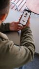 Un client consulte des informations sur un smartphone à une table de café