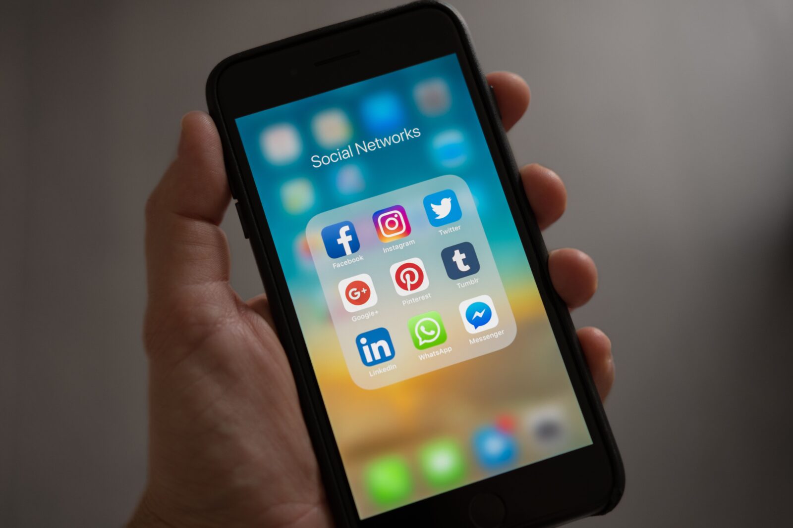 Hand houdt smartphone vast met social media-apps op het scherm