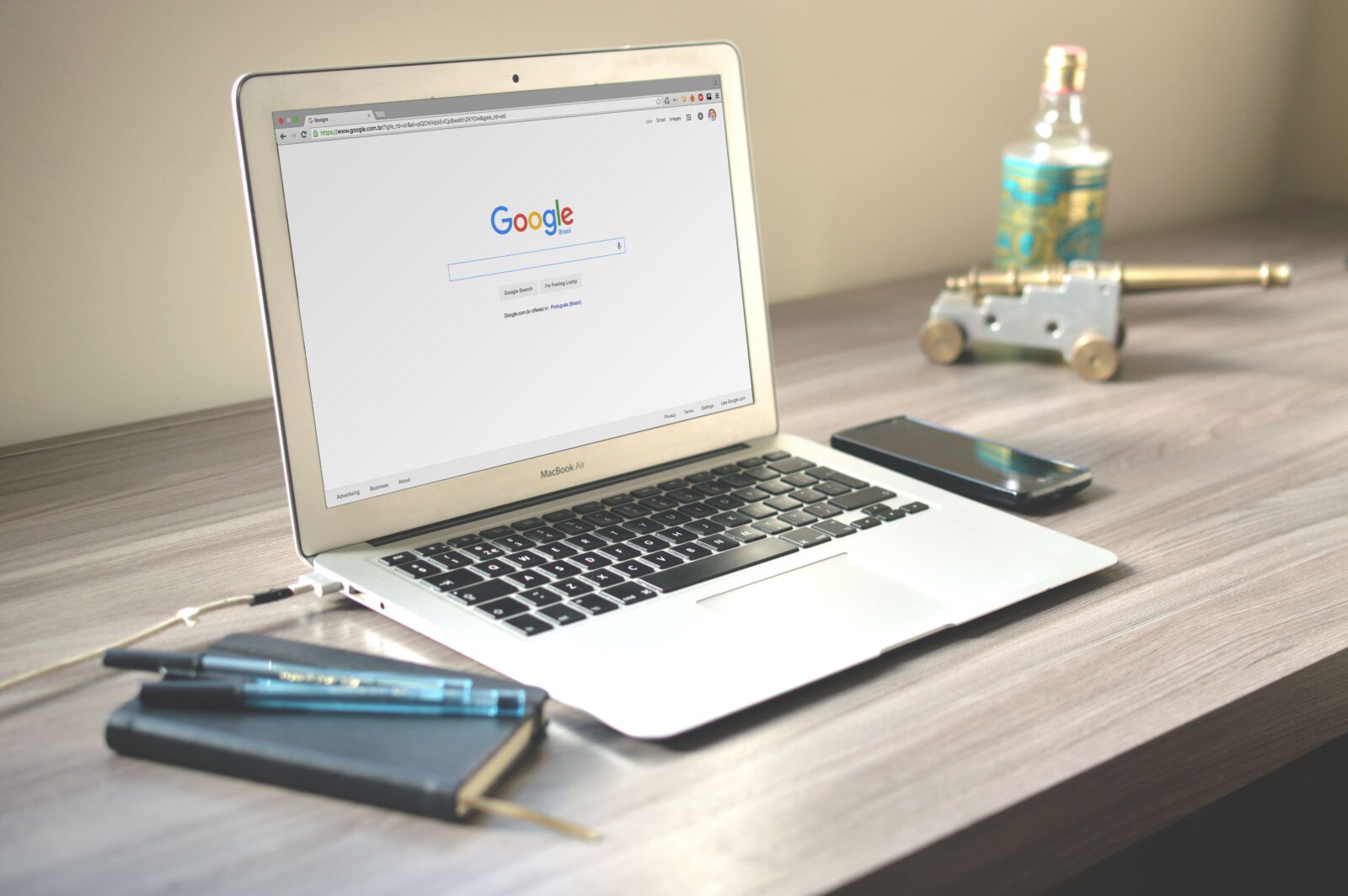 Laptop met een Google-zoekpagina op een opgeruimd houten bureau