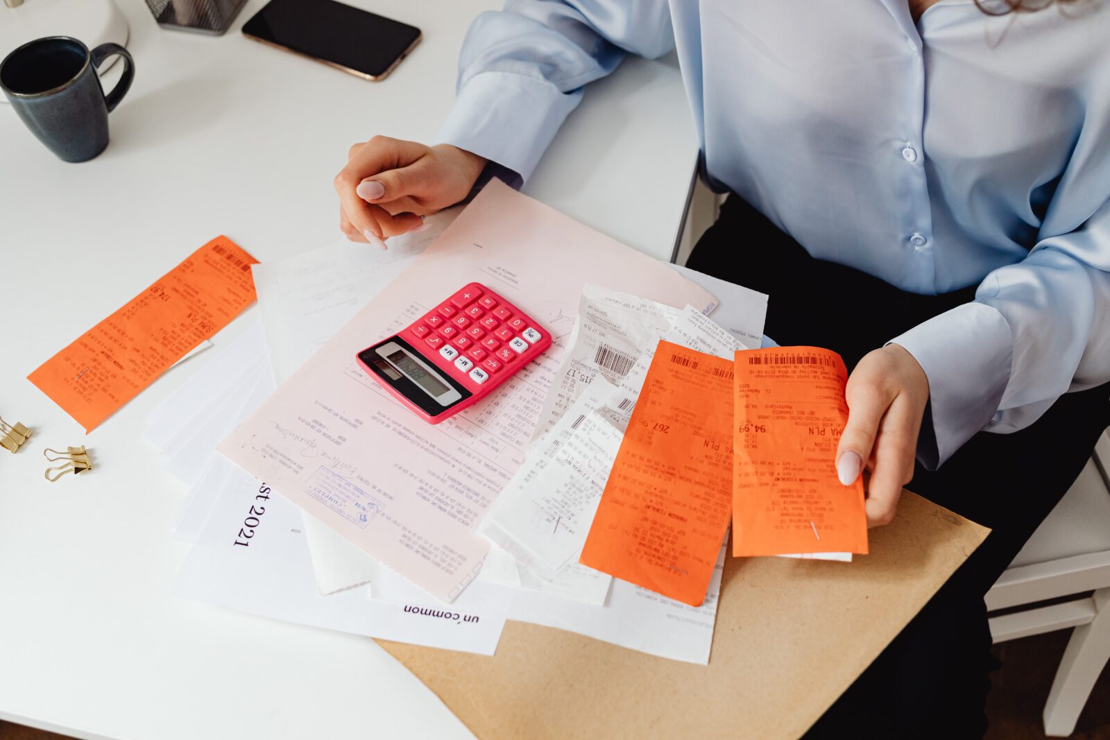 Une personne calcule des prix de menu avec une calculatrice et des tickets de caisse
