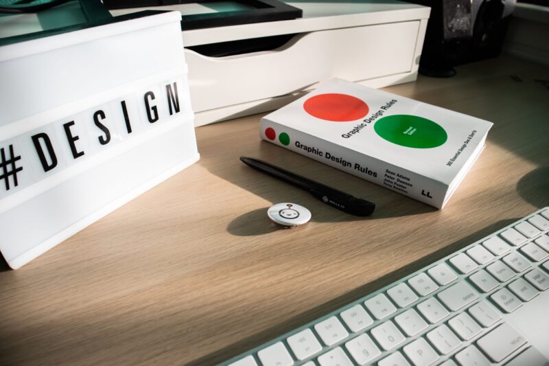 Aufgeräumter Schreibtisch mit Laptop und Design-Material