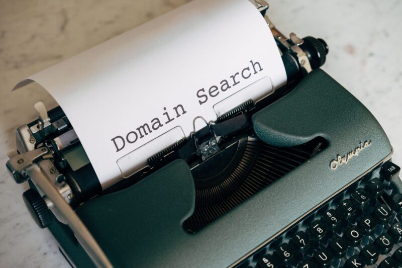 Schreibmaschine mit einem Blatt, auf dem "Domain Search" getippt ist