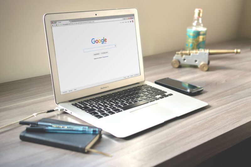 Laptop mit einer Google-Suchseite auf einem ordentlichen Holzschreibtisch