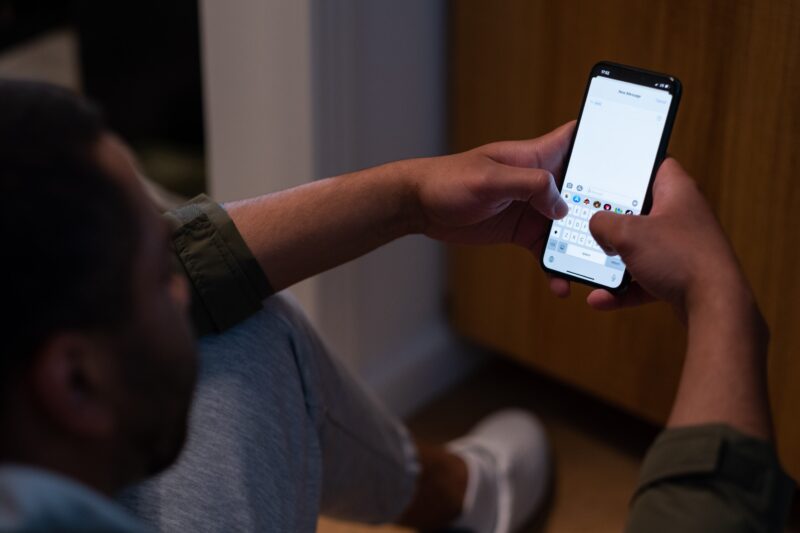 Persoon typt een WhatsApp-bericht op een smartphone als contactkanaal